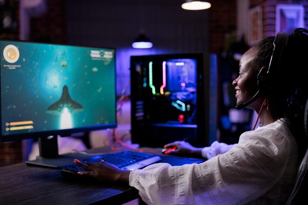 african american woman playing shooting video games on pc